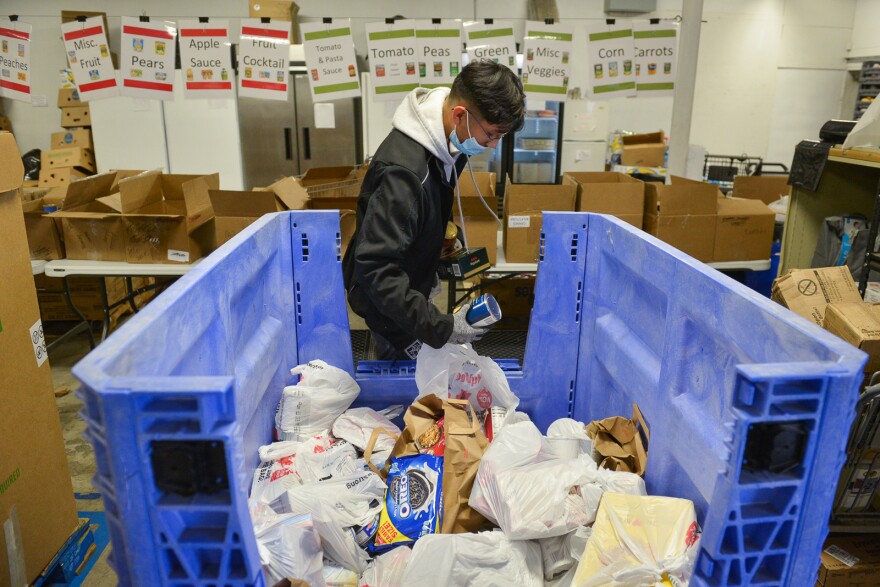 Emmanuel Olvera, a volunteer at Hope Distribution Center in Kansas City, Kansas, sorts through a bin of donated food Wednesday. Food pantries in the metro report they generally are keeping up with the increased demand due to high food prices and lingering pandemic unemployment.