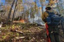 A firefighter from the Minnesota Department of Natural Resources observes the Crosby Fire in October 2025. The fire is burning in a remote ridge area within the George H. Crosby Manitou State Park.