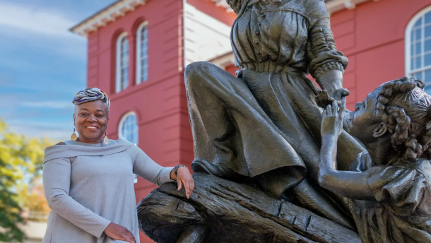Adrian Holmes poses with the "A Beacon of Hope" Harriet Tubman statue in front of the Dorchester County Courthouse in Cambridge.