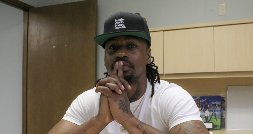 A portrait of De’Vonté  Parson sitting at a desk.