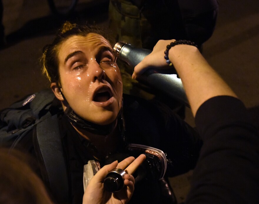 A protestor gets her eyes flushed after clashes broke out on Black Lives Matter Plaza.