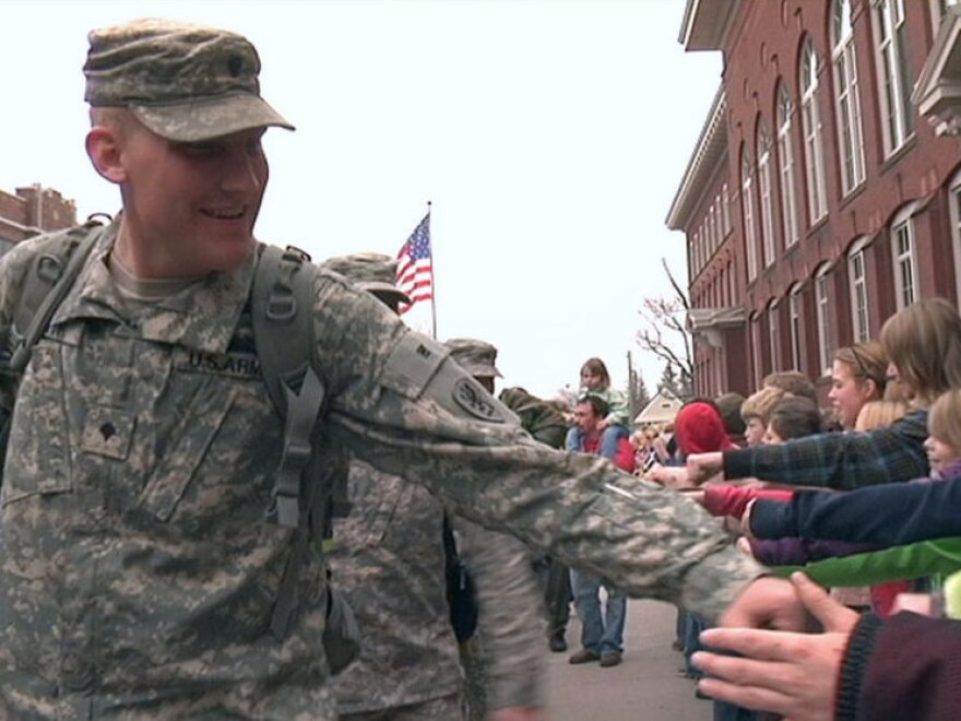 Cole Smith, who served as a driver and gunner in convoys looking for roadside bombs in Afghanistan, greets crowds in his hometown of Hancock, Mich.