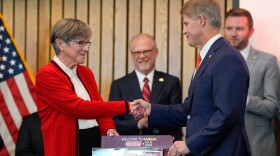 Kansas City Chiefs owner Clark Hunt, right, and Kansas Gov. Laura Kelly, shake hands during an event Monday, Dec. 22, 2025 in Topeka, Kansas, announcing the team will leave Arrowhead Stadium in Kansas City, Missouri, for a new stadium that will be built across the Kansas-Missouri state line.