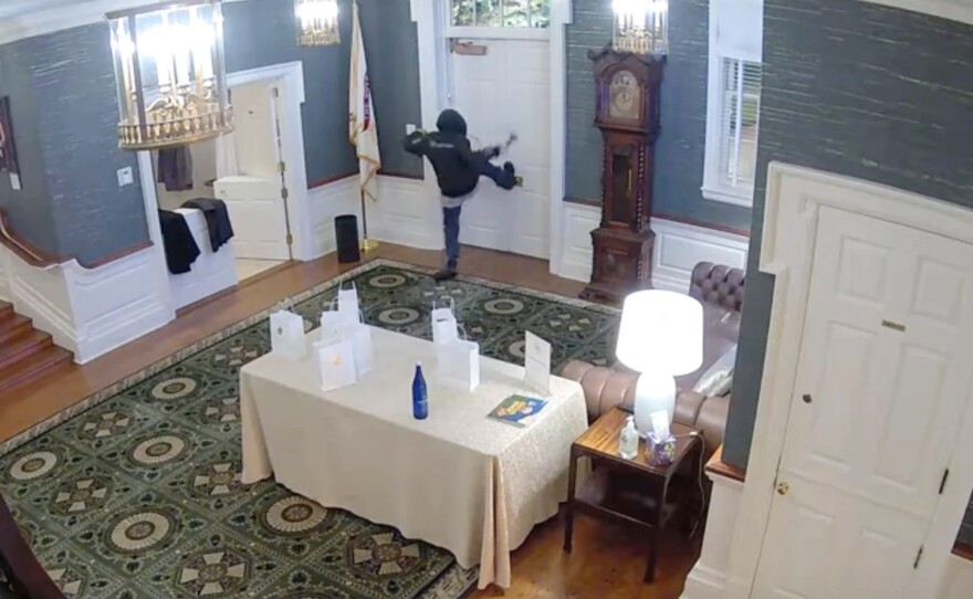 This image made from a surveillance video provided by the Dauphin County District Attorney's Office shows Cody Balmer holding a Molotov cocktail and striking at a door leading to where Gov. Josh Shapiro, his family and guests slept in the governor's mansion on April 13, 2025, in Harrisburg, Pa.