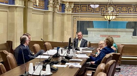 Oklahoma Treasurer Todd Russ, seen through a window, discusses options with attorneys during an executive session of the Tobacco Settlement Endowment Trust Board of Investors at the Capitol in Oklahoma City on Wednesday, July 1, 2026.