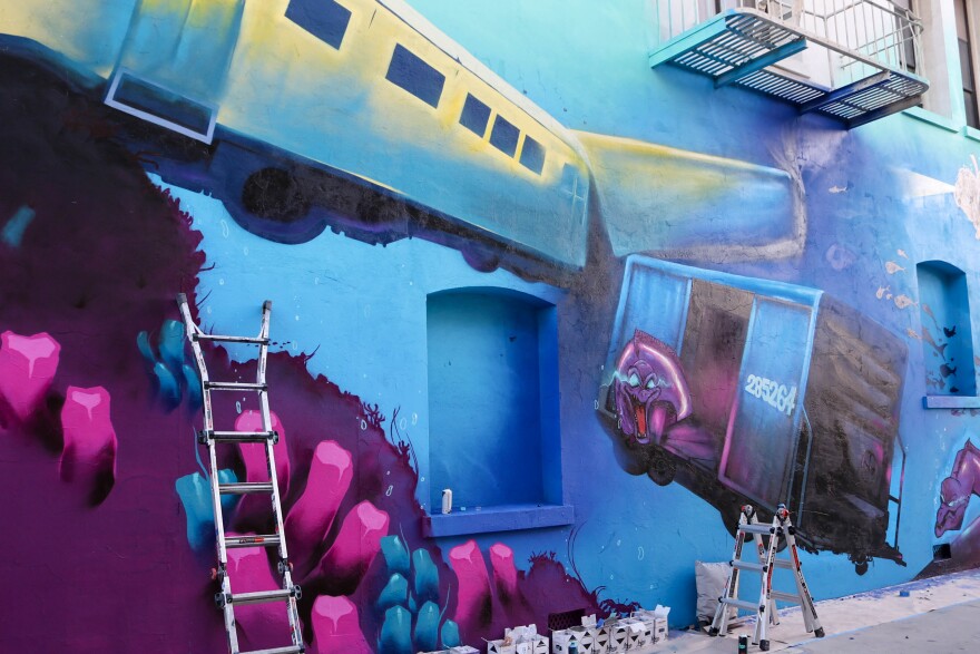 Another mural in an alleyway shows submerged train cars and electric eels.