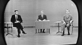 FILE - In this Sept. 26, 1960 file photo, moderator Howard K. Smith sits between, Sen. John Kennedy, left, and Vice President Richard Nixon as they appear on television studio monitor set during their debate in Chicago. (AP Photo)