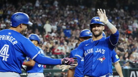 Kevin Kiermaier smiles, waves to crowd while being congratulated by a teammate