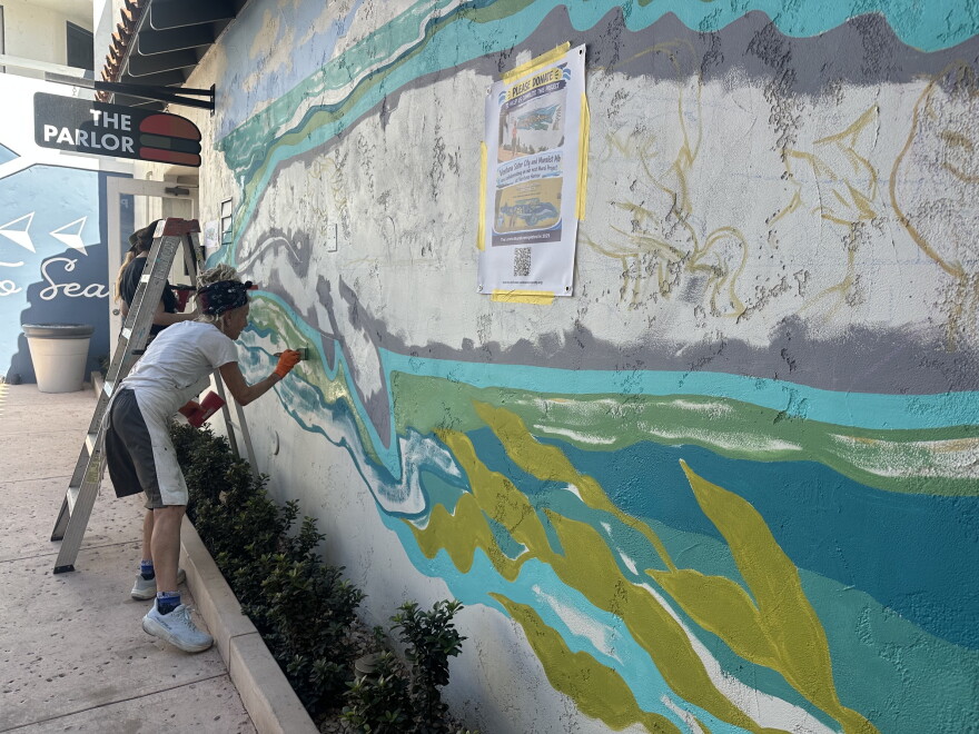 Artist M.B. Hanrahan works on a whale mural at Ventura Harbor Village which mirrors a mural she helped create in Ventura's sister city of Loreto, Mexico.
