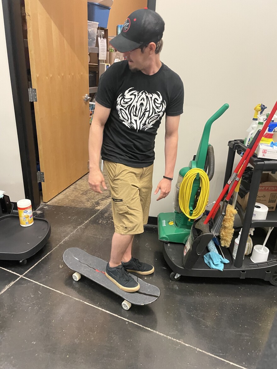 Mason Wicker skateboards between rooms in the long halls at the warehouse-converted church in Mansfield where he works.