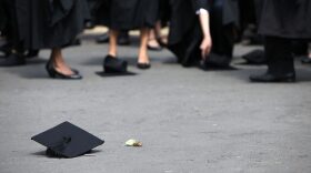 Students pick up their mortarboards after the offical hat throwing photograph at the University of Birmingham in Birmingham, England.