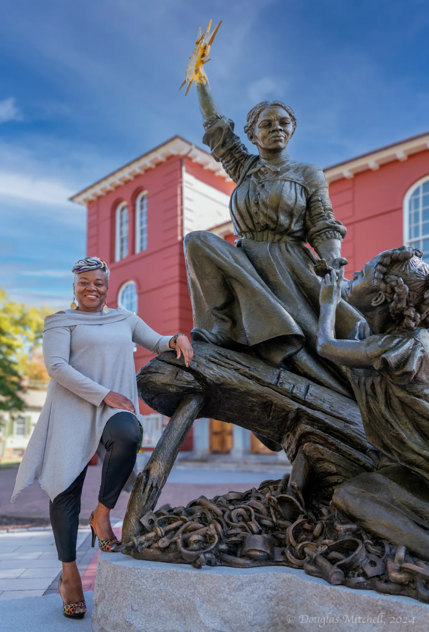Adrian Holmes poses with the "A Beacon of Hope" Harriet Tubman statue in front of the Dorchester County Courthouse in Cambridge.