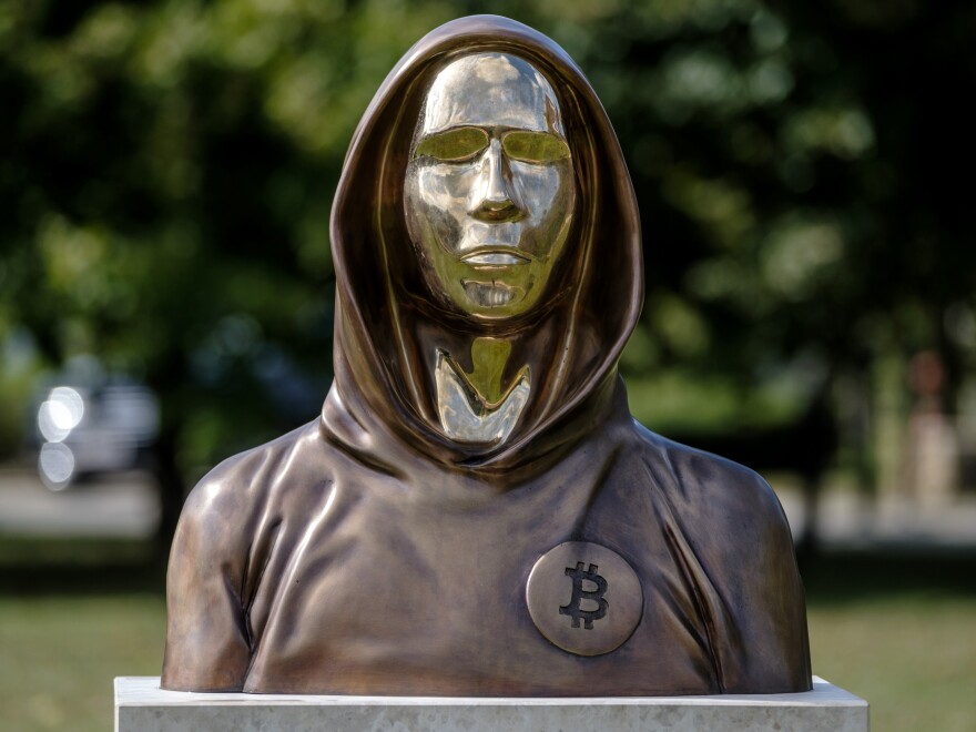 A statue of Satoshi Nakamoto, a presumed pseudonym used by the inventor of bitcoin, is displayed in Graphisoft Park in 2021 in Budapest, Hungary. The statue's creators, Reka Gergely and Tamas Gilly, used anonymized facial features, as Nakamoto's true identity remains unconfirmed.