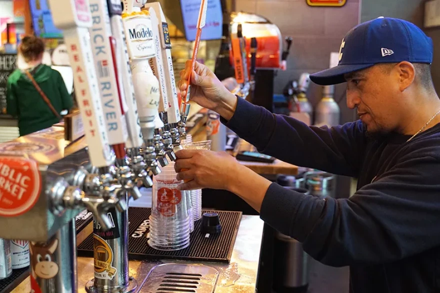 A bartender pours a beer at Topp'd Pizza in Lenexa.