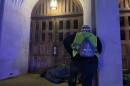 A volunteer participating in the Point-in-Time Count surveys a person sleeping outside First United Methodist Church in Uptown.