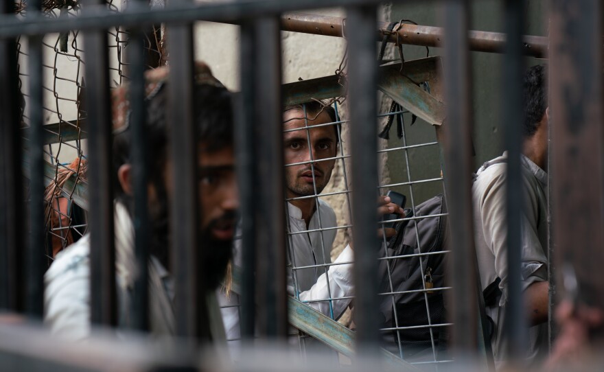 People wait on the Afghanistan side at Torkham border, either to leave the country or greet returnees.