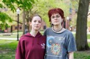 Two young people pose for a photo on a college quad