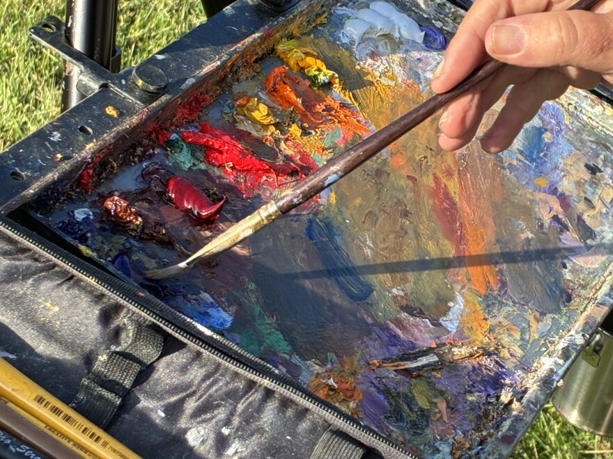 Elbert Shubert of Pilot Mountain, North Carolina, applies paint to his brush during the 2026 Floyd Plein Air Biennial.