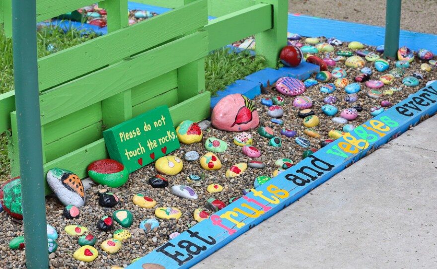 These painted rocks feature images of the sorts of fresh fruits and veggies grown in the garden. The rocks were painted by students.