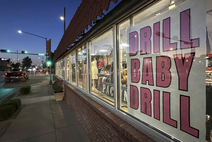 A sign in support of the oil and natural gas industry is displayed in a shop window along a main street in Carlsbad, N.M., on Tuesday, May 20, 2025. (AP Photo/Susan Montoya Bryan)