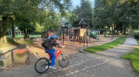 Biker passing through playground.