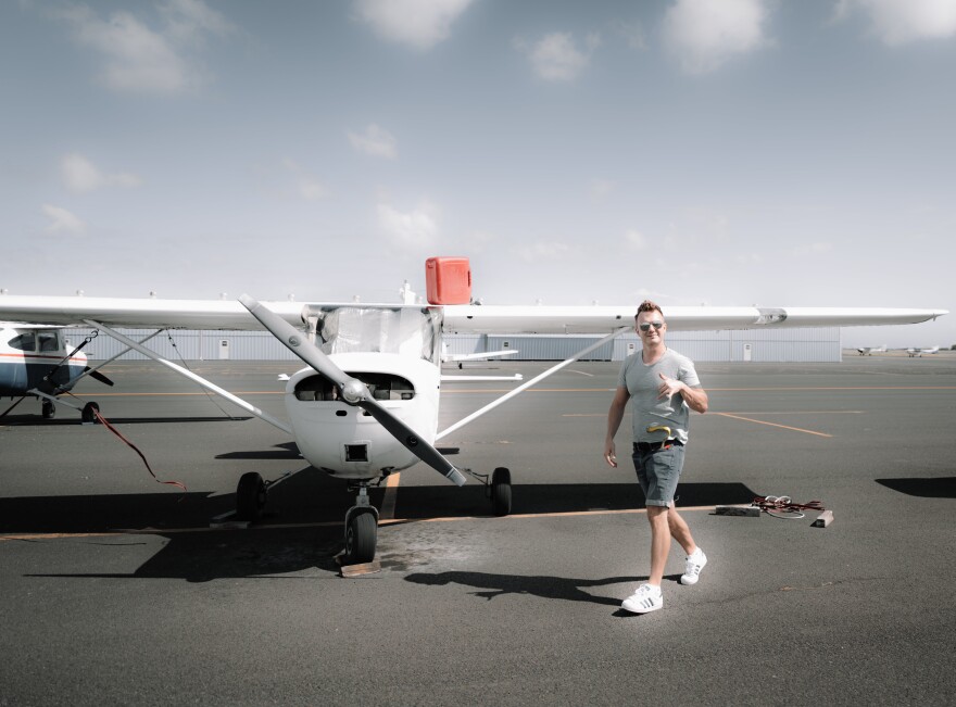 Cheerful man walking near contemporary propeller aircraft