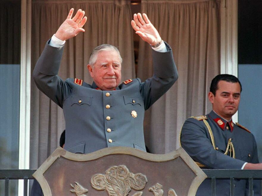 Gen. Augusto Pinochet waves to supporters from the balcony of his residence in Santiago, Chile, during the celebration of the 22nd anniversary of the 1973 military coup he led to oust President Salvador Allende.