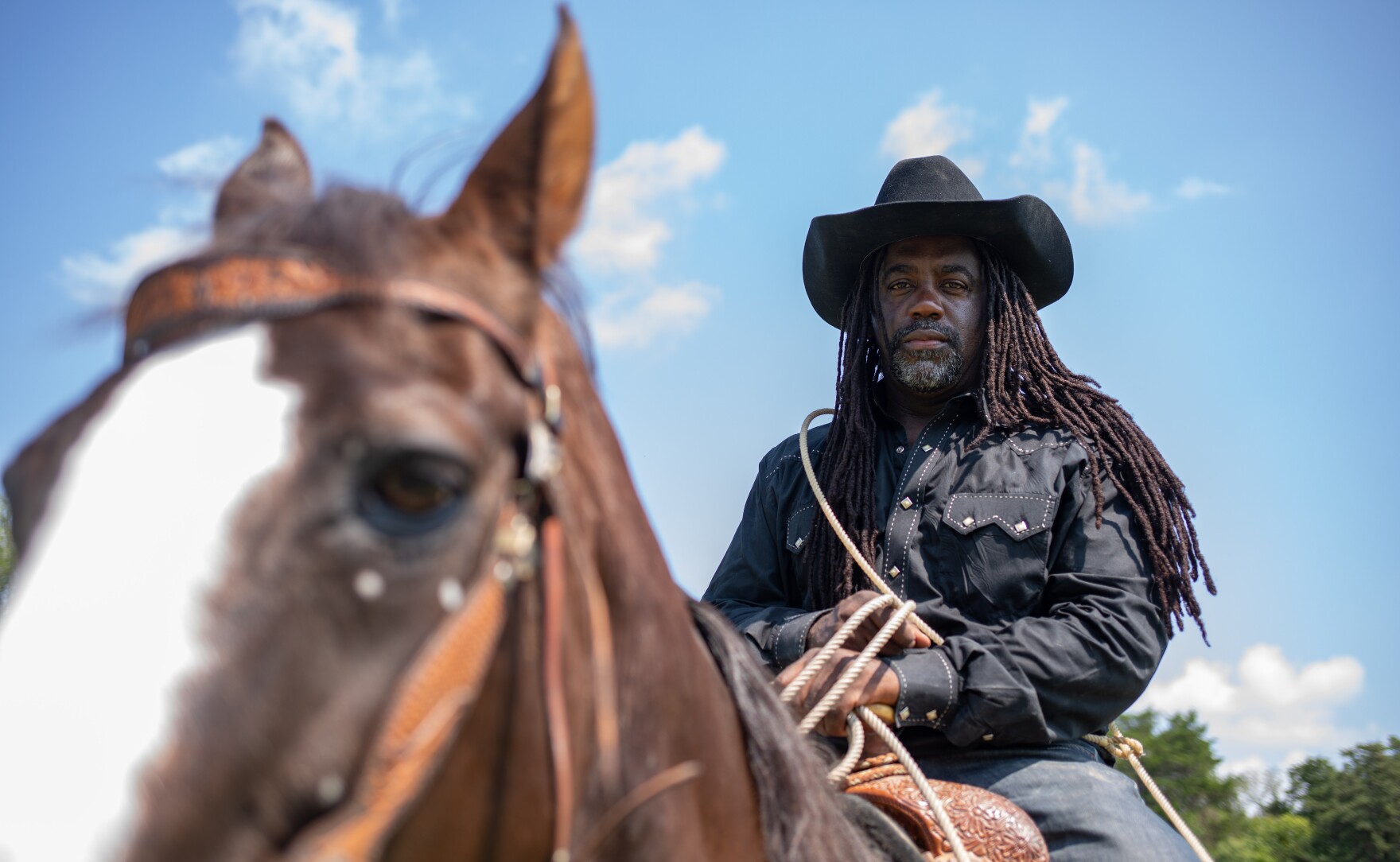 Ke ' Elronn Hatley chevauche un cheval avec son lasso en position prête.