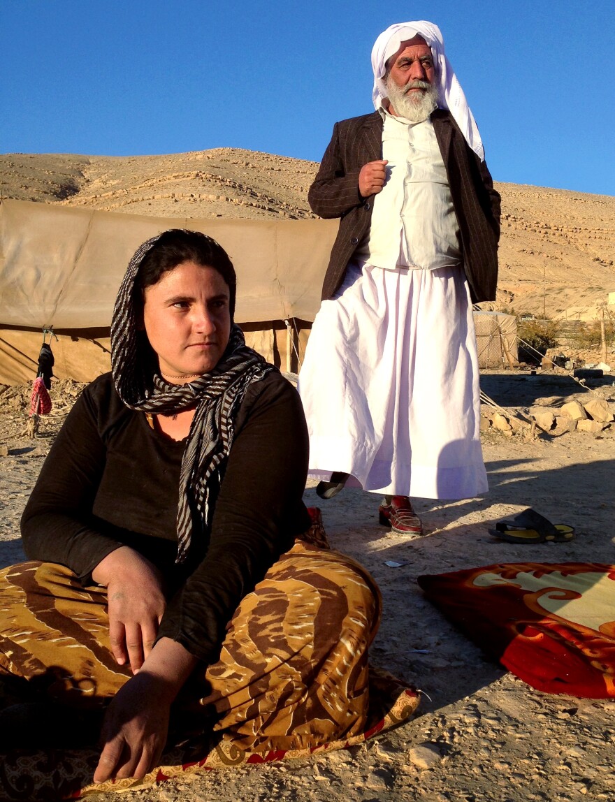Sevi Zendi, from Iraq's Yazidi minority, says her family sleeps with guns in their tent in case ISIS reaches the exposed encampment. Standing behind her is family patriarch Abdi Ismail, who says that his whole family accepted the decision to stay on Mount Sinjar, passing up the opportunity to escape the ISIS siege when a path was opened.