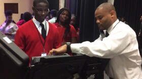 students try out a voting machine in Jennings