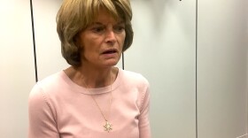 Sen. Lisa Murkowski in her Washington, D.C. office. She caught the salmon mounted on the wall behind her. She calls him Walter. Photo by Liz Ruskin.