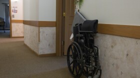 A wheelchair sits outside a resident’s room inside an assisted living facility in Horicon, Wis., Aug. 15, 2024. (Joe Timmerman / Wisconsin Watch)