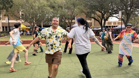 Aldo Garza, the president of the Pride Community Center and event organizer, dances with an attendee on Saturday, Oct. 3, 2026. (Madison Middleton/WUFT News