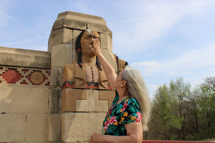 Susie Cunningham touches a Native American Bust on Minisa Bridge in Wichita. She says the Native American busts on the South-West end of the bridge have some of the worst damage.