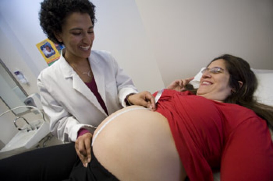 A Duke doctor examines a pregnant woman.