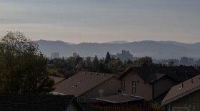 Reno Skyline with a hot air balloon next to it, houses in the foreground and the mountains in the background