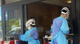 FILE - Hospital workers process COVID-19 tests at a hospital in Aiea, Hawaii, Wednesday, Sept. 15, 2021. The Centers for Disease Control and Prevention posted revised guidelines on Thursday, Dec. 23, 2021, that are loosening rules that call on health care workers to stay out of work for 10 days if they test positive for COVID-19. Those workers will be allowed to come back to work after seven days if they test negative and don’t have symptoms. (AP Photo/Caleb Jones, File)