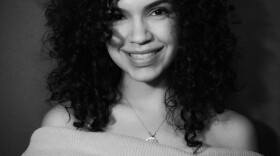 A black and white headshot of Stephanie Serrano. She is looking toward the camera and smiling.