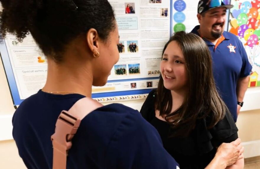 Camila Nino (right), 11, is greeted by a staff member at TIRR Memorial Hermann. Camila suffered an ischemic stroke this past February.