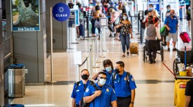 A group of masked TSA employees walks through the Barbara Jordan Terminal at Austin-Bergstrom International Airport