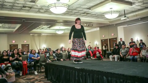 Sixteen-year-old Adrionna Otis walks the runway in fashion show, Miskwaa Niigaan. She wore a floral-patterned ribbon skirt and a pair of earrings she made at Fortune Bay Resort Casino on March 27, 2026 in Tower.