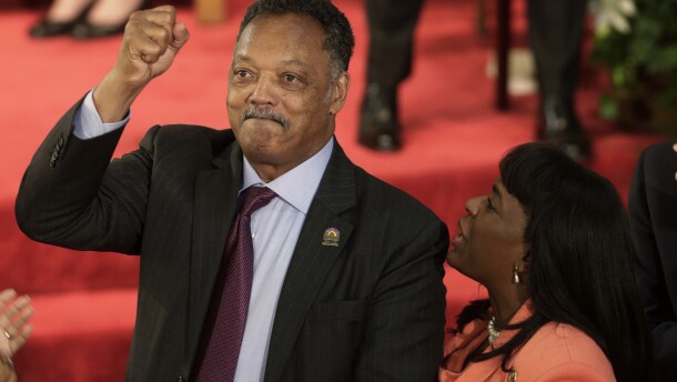 FILE - Rev. Jesse Jackson gestures to a friend in the balcony at the 16th Street Baptist Church in Birmingham, Ala., Sept. 15, 2013. The church held a ceremony honoring the memory of the four young girls who were killed by a bomb placed outside the church 50 years ago by members of the Ku Klux Klan. At right is U.S. Rep. Terri Sewell, D-Ala. (AP Photo/Dave Martin, File)