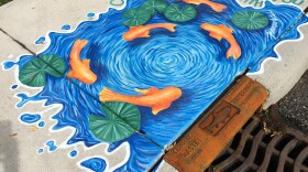 A sidewalk mural painted in Goshen to raise public awareness about how storm sewers feed into rivers and streams. The city of South Bend is borrowing the idea for a new public sidewalk mural contest.