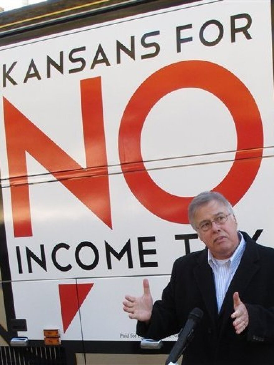 In Kansas, legislators are considering devoting extra funds to tax relief instead of hiring more state workers. Republican state Rep. Joe Patton of Topeka, shown in November, talks about proposals to eliminate the state's income tax.