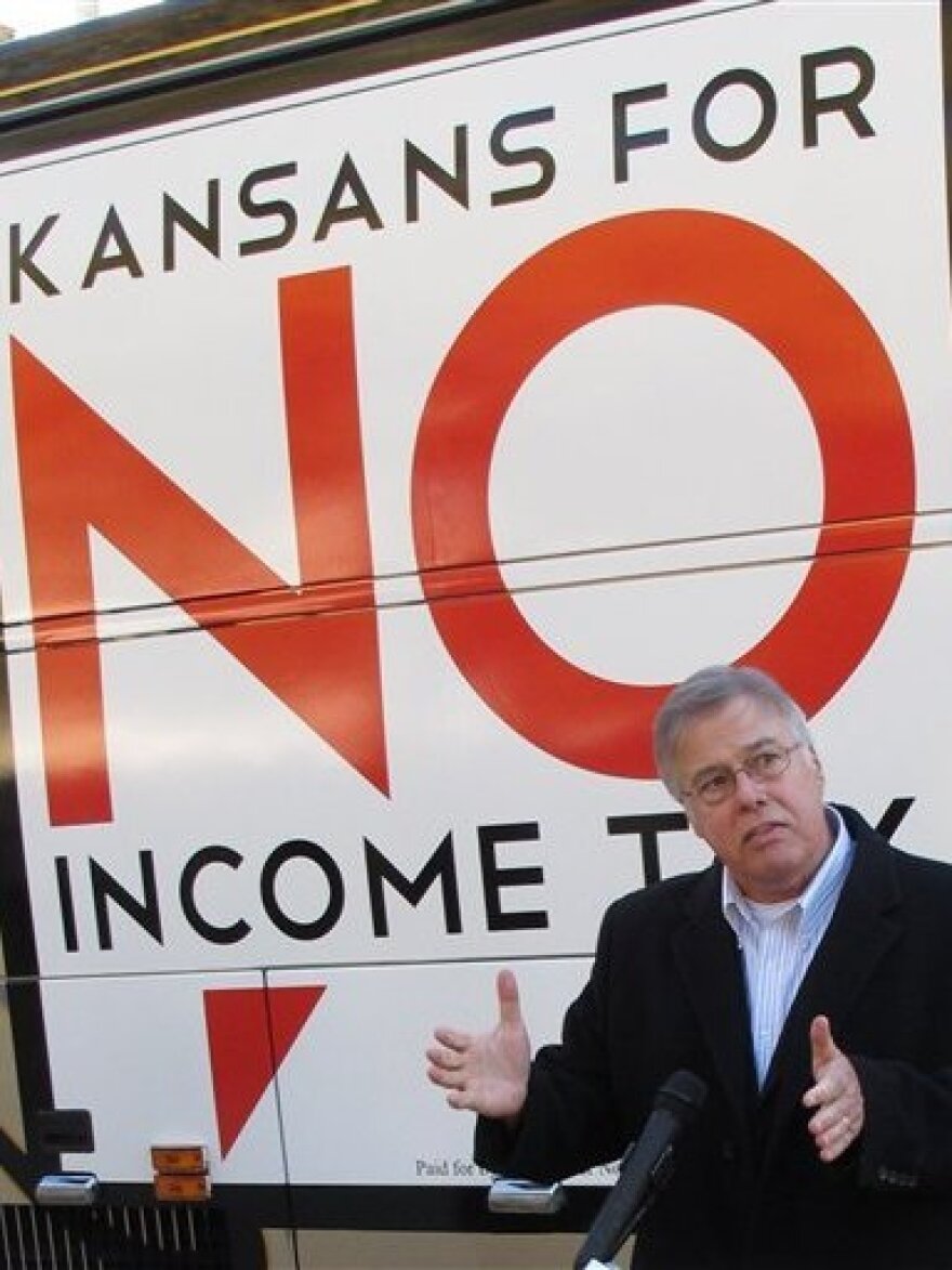 In Kansas, legislators are considering devoting extra funds to tax relief instead of hiring more state workers. Republican state Rep. Joe Patton of Topeka, shown in November, talks about proposals to eliminate the state's income tax. 