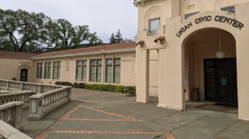  A pinkish building with an arched doorway and a sign saying, "Ukiah Civic Center."