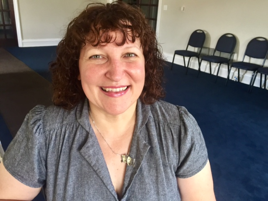 Photo of woman inside room with chairs lined against wall