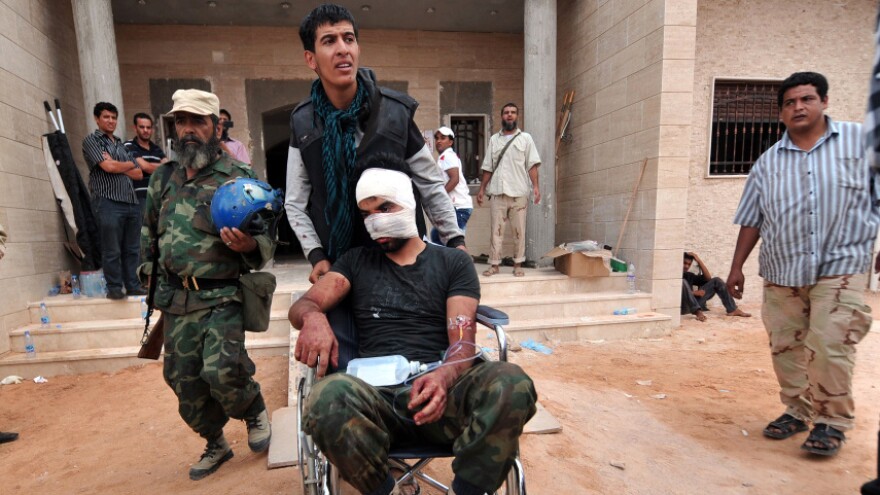 <p>On a morning of fierce street fighting, a wounded man is wheeled into a field hospital outside Sirte. The city was rocked by explosions, and Libyan National Transitional Council fighters were targeted by pro-Gadhafi snipers.</p>