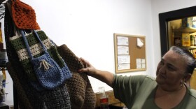 A woman showcases her hand-crocheted bags in her restaurant