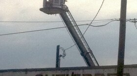 The Tulsa Fire Department uses a snorkel truck to look down on the damage.